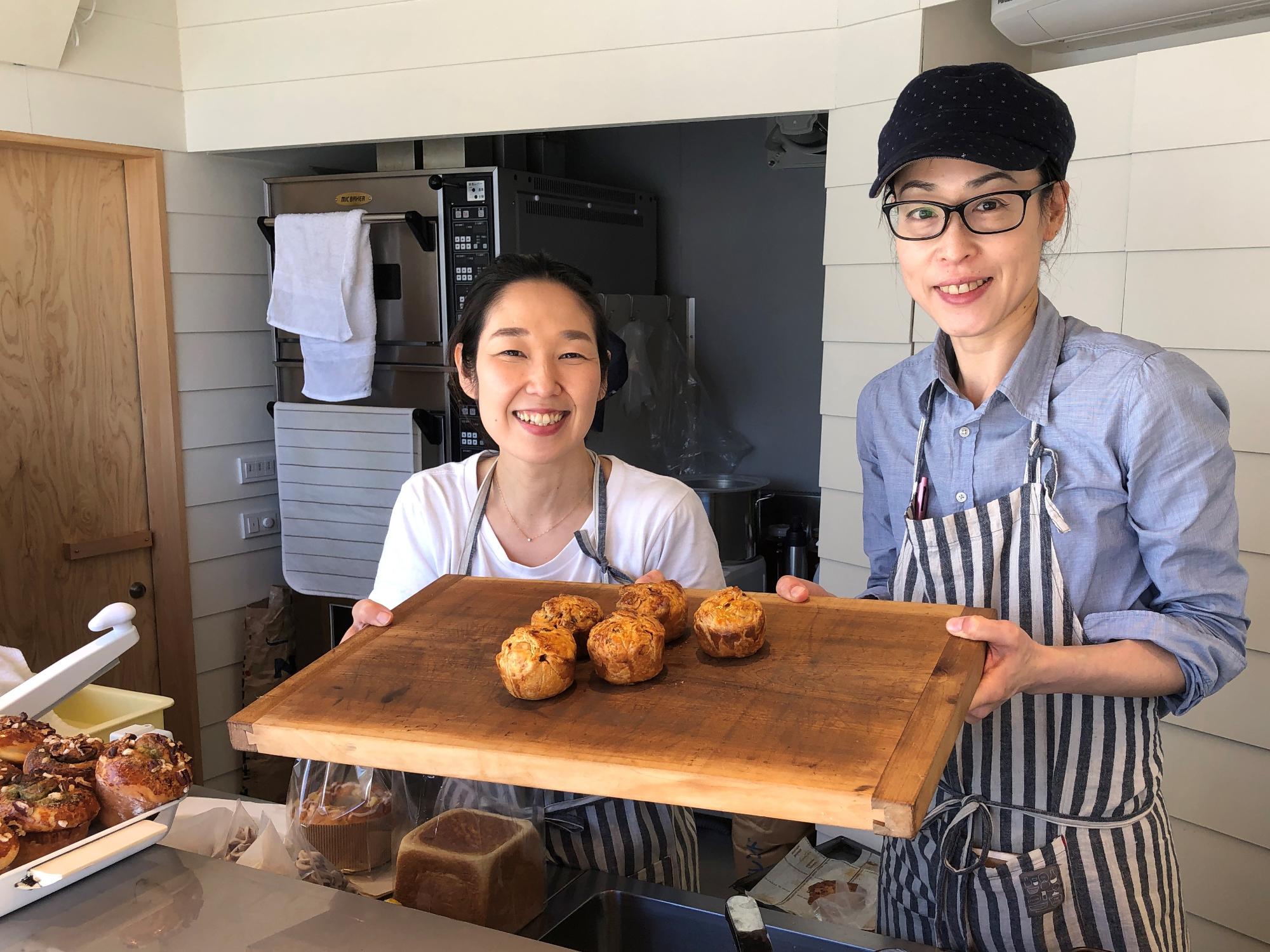 焼きあがったミートパイをもつ2人の女性
