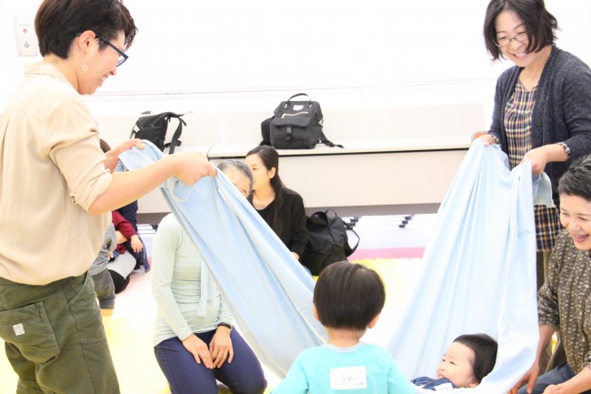 シーツで寝転ぶ子供