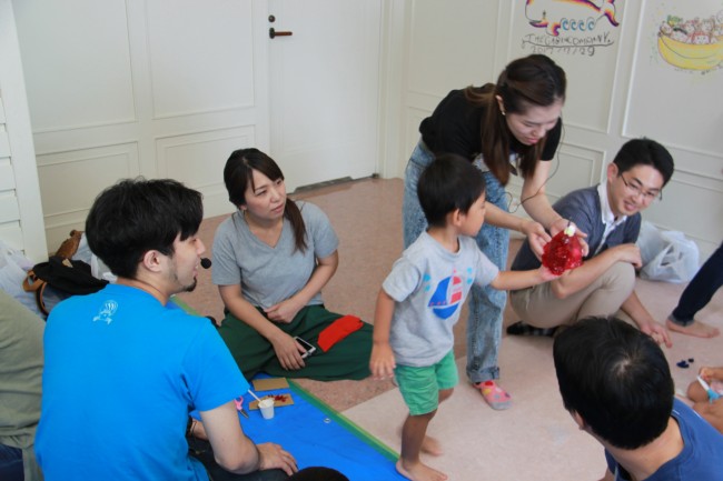 作品を阿部健太郎さん吉岡沙希さんに見せる子供の写真