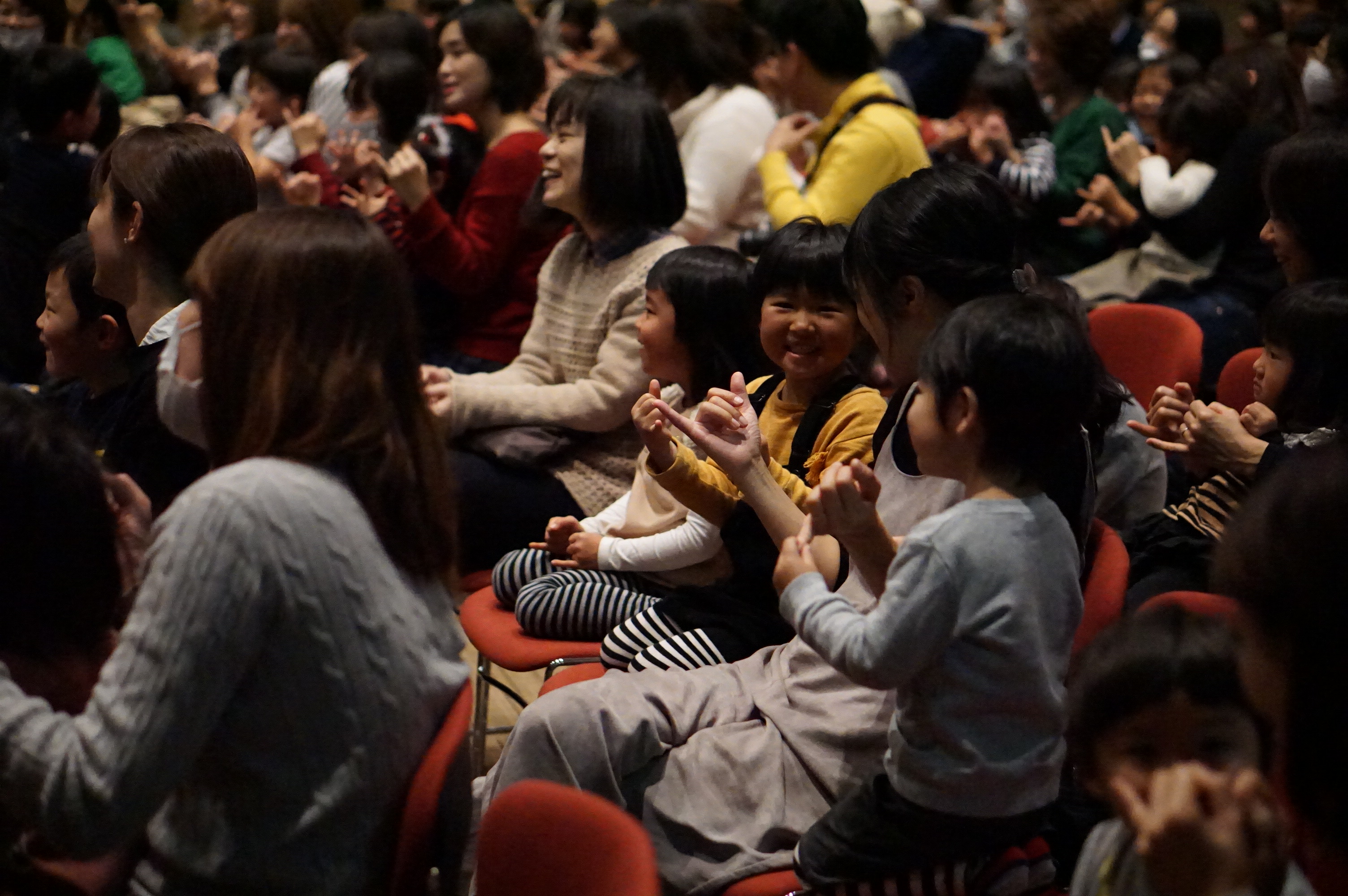 観客席で大友さんの手の動きを真似ようする子どもたちの写真