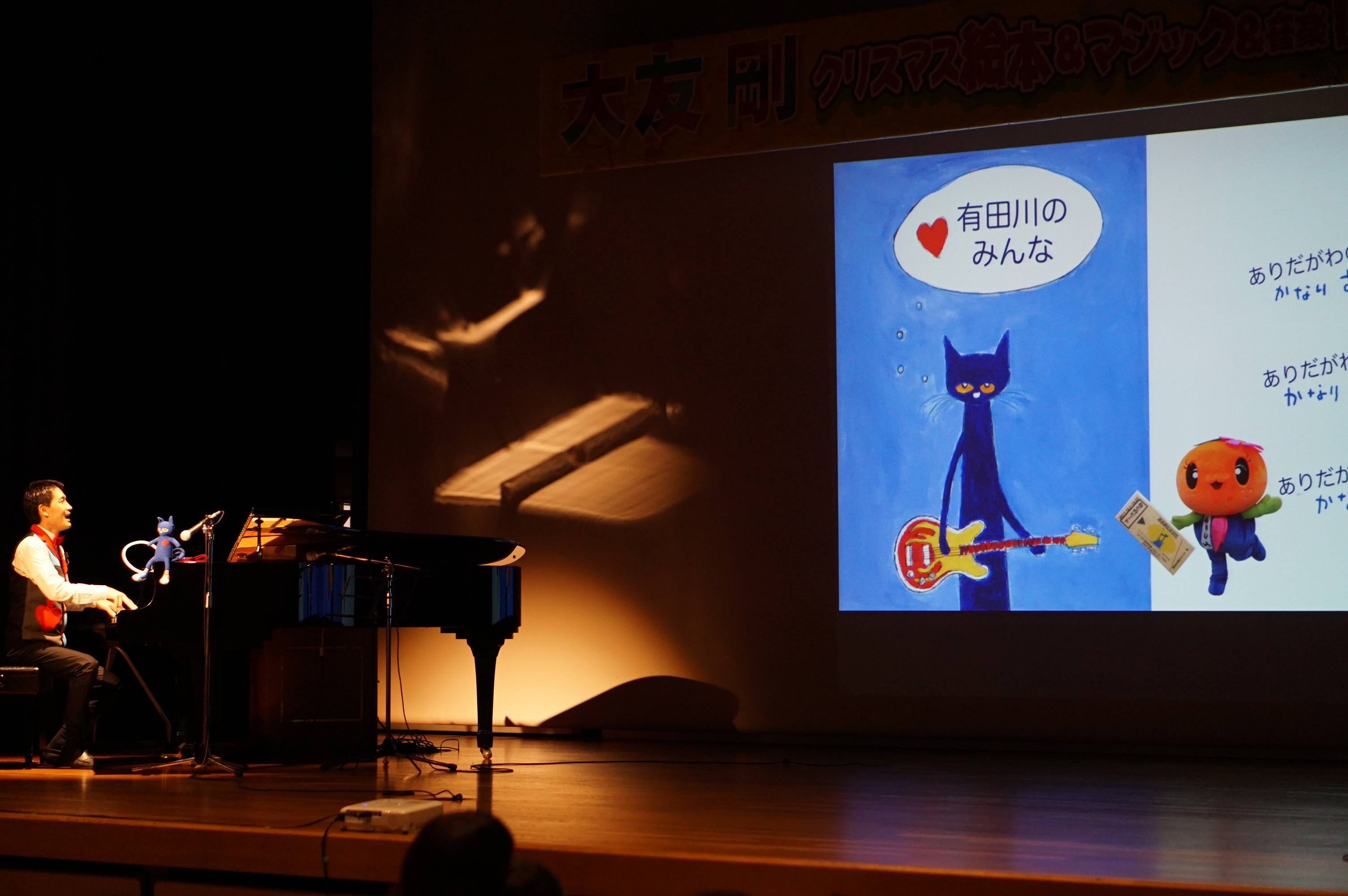 スクリーンに映し出された猫のピートとキャラクターのありりんの写真