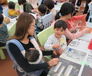 お母さんと一緒に作業をする子どもの写真