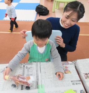 トナカイペットボトルを転がしてみる子どもの写真