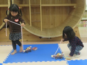 トナカイペットボトルの鼻部分につけられたひもを引っ張ってトナカイを連れ歩く子どもたちの写真