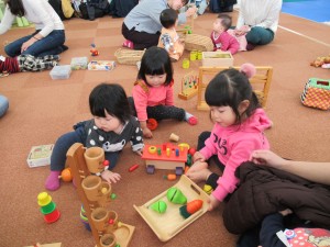 おままごとなどの木のおもちゃで遊ぶ子どもたちの写真