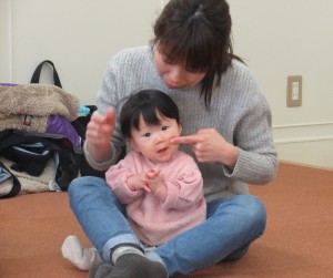 お母さんにほっぺをつんつんされている子どもの写真