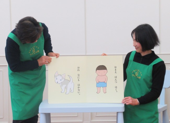 読み聞かせの絵本で、おしりを見せているハスキー犬とパンツをはいている子どものシーンの写真