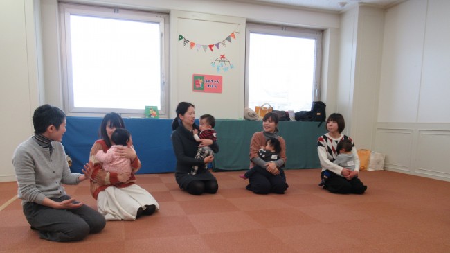 おかあさんが膝の上で赤ちゃんを抱く様子の写真