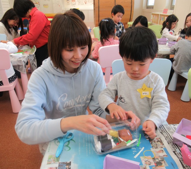 大人と一緒にお弁当のレイアウトを考える子どもの写真
