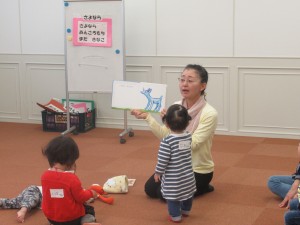 赤ちゃんに読み聞かせをする女性の写真