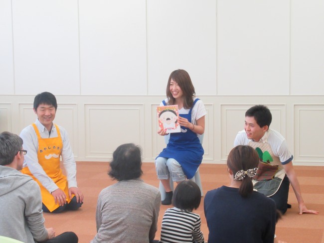 おはなしマラソンでスタッフが絵本の表紙を見せている写真