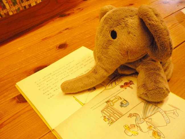 ゾウのぬいぐるみが絵本を読んでいる風の写真