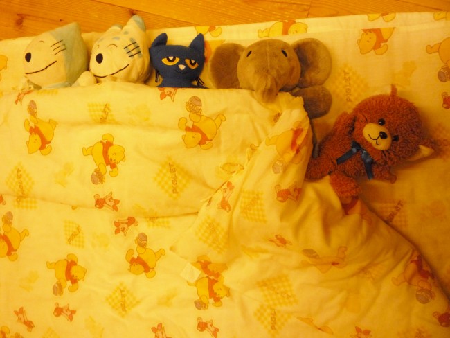 五体のぬいぐるみがお布団の中で仲良く眠っている風の写真