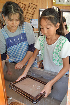 女の子が紙漉体験をしている様子