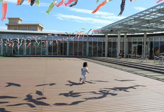 鯉のぼりの下で走りまわる子どもの写真