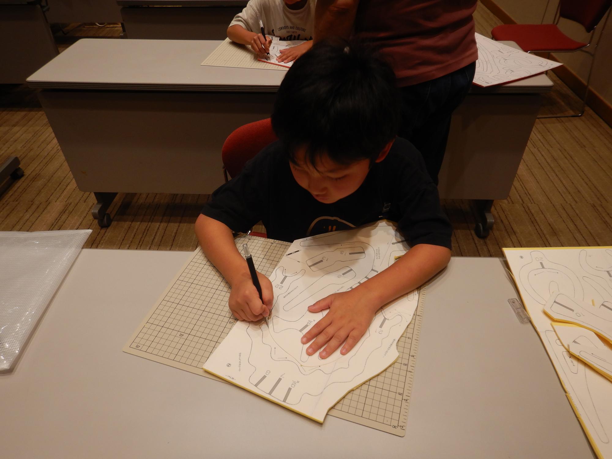 描かれた型に沿って切っている様子