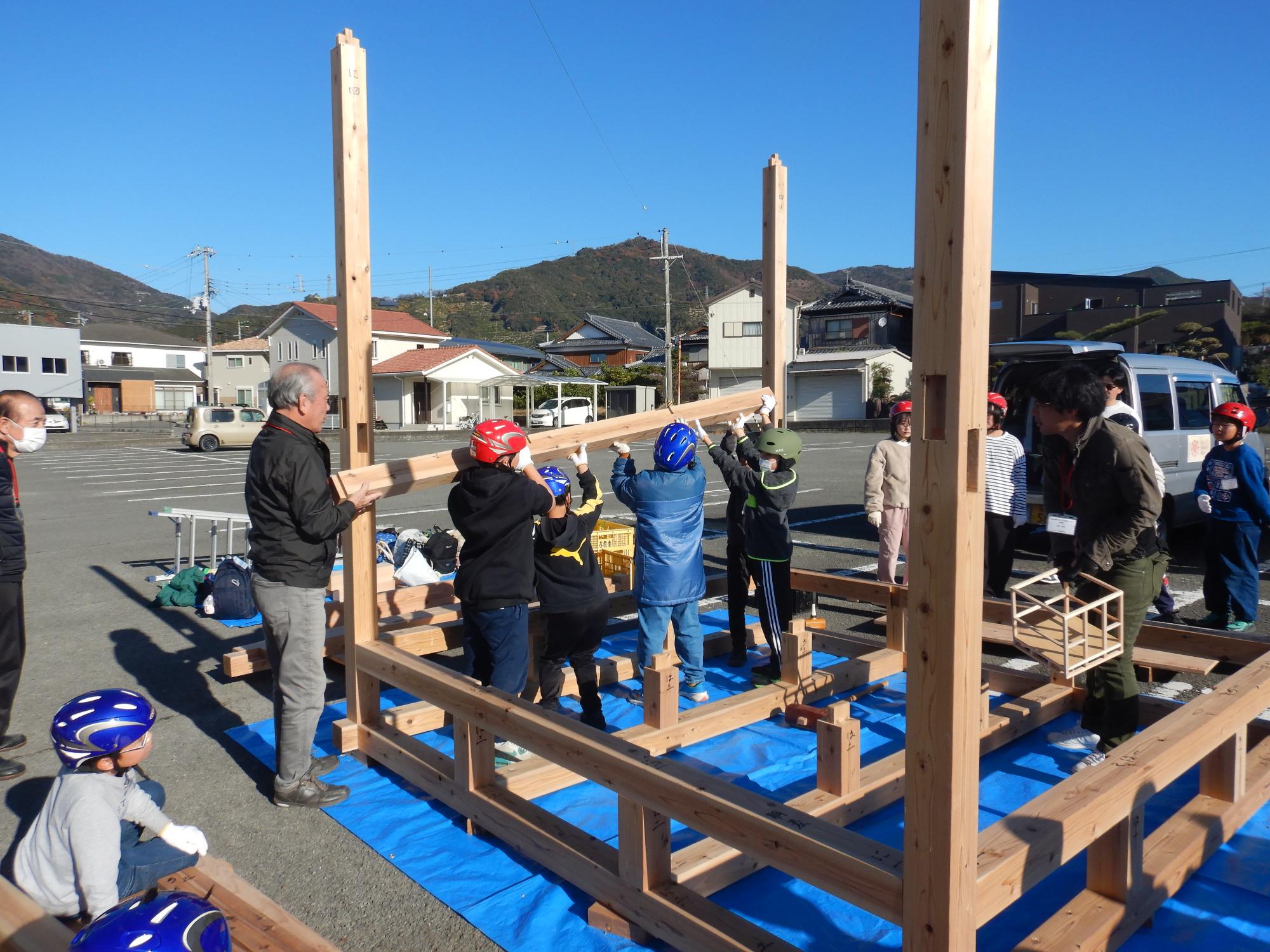 班で協力して木材を運んでいる様子