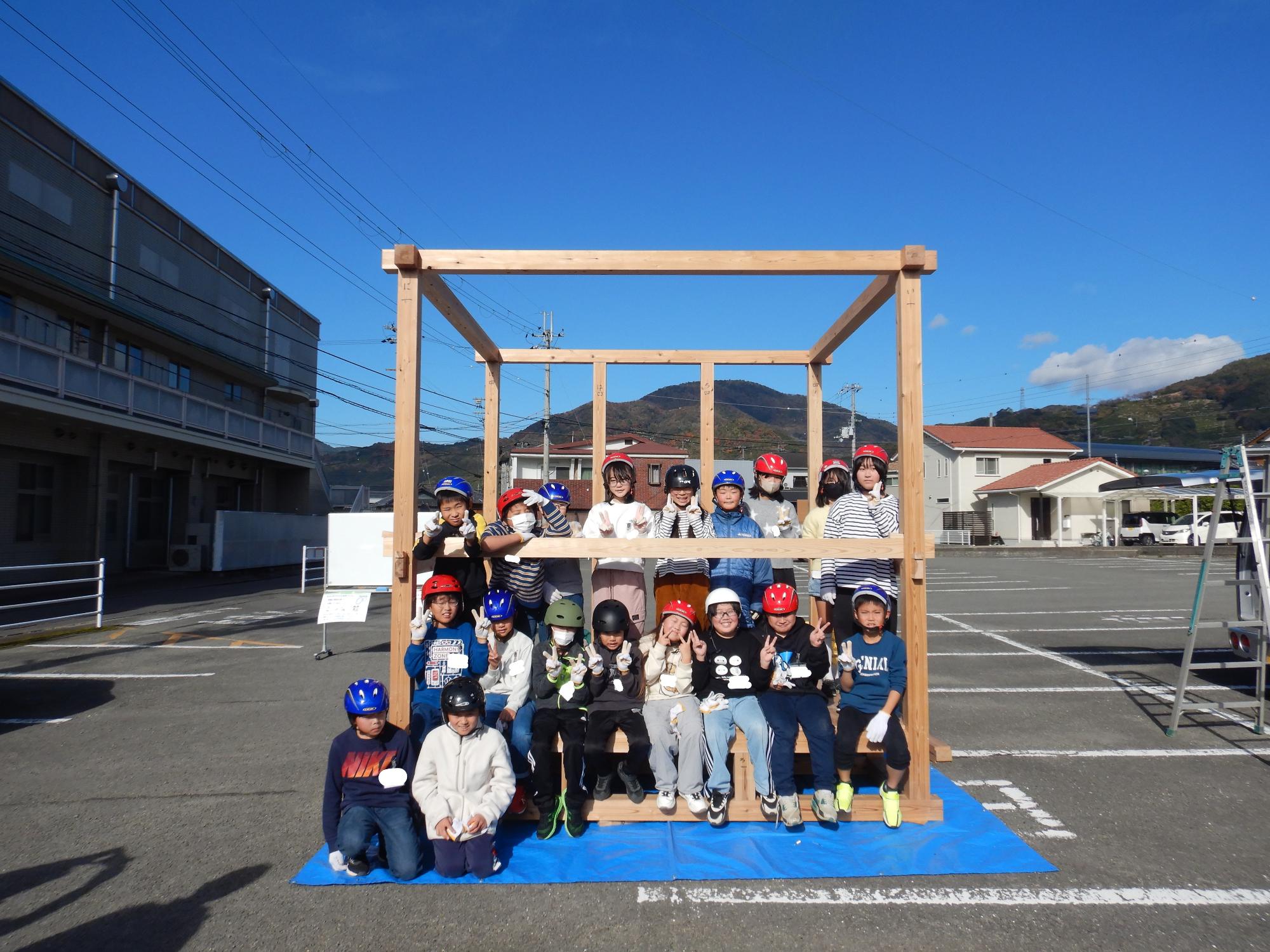 完成したやぐらにのってみんなで集合写真を撮っている様子