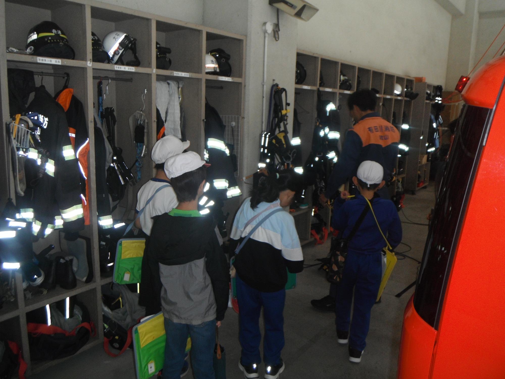 実際に現場で使用される資器材について、消防署員から小学生に説明をしている様子です。