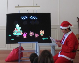 「ほしのクリスマス」のワンシーンの絵とサンタの扮装をしたスタッフの写真