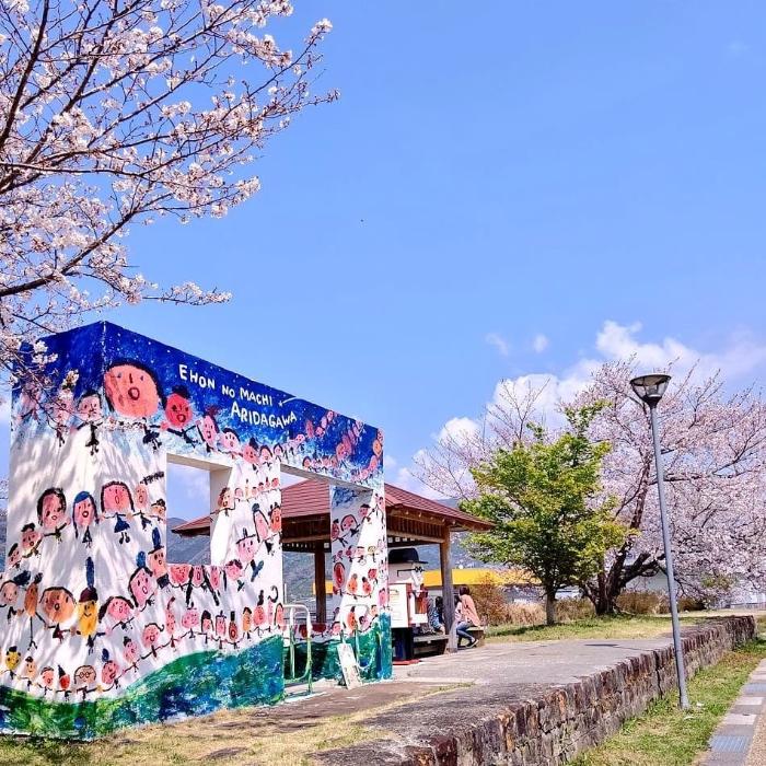 ポッポ道沿いにある旧田殿口駅舎と桜の写真